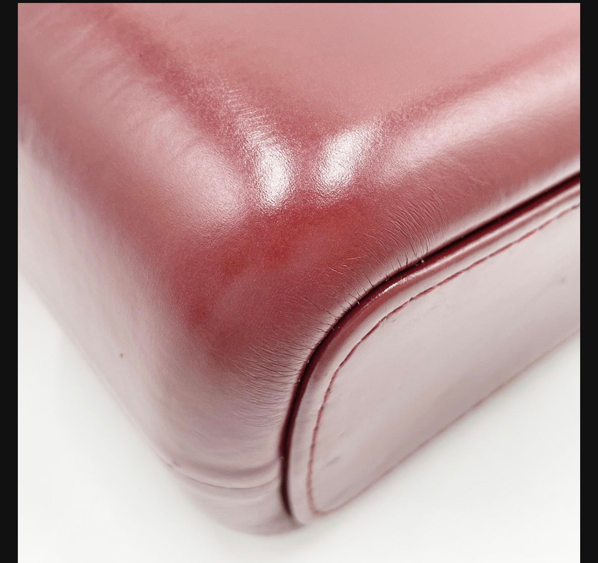 Chanel Gabrielle burgundy leather lower corner with visible scuffs and creasing
